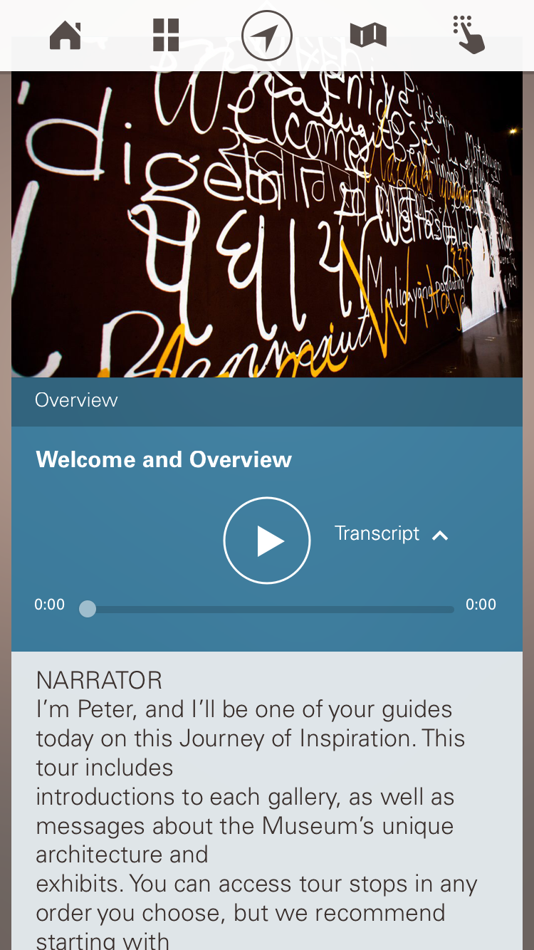 A smartphone app or mobile webpage for a museum audio guide. At the top is a navigation bar with icons for home, grid/menu, compass/location, map, and a hand/tap symbol. Below it is a wide banner photo of a dark wall covered with bright white and yellow handwritten-style text projections. Under the photo, a teal section is labeled "Overview," followed by the audio stop title "Welcome and Overview." A large circular play button appears in the center, with "Transcript" and an upward caret to the right. A progress bar below shows the audio at 0:00 on both ends. The transcript area begins with "NARRATOR" and text: "I'm Peter, and I'll be one of your guides today on this Journey of Inspiration. This tour includes introductions to each gallery, as well as messages about the Museum's unique architecutre and exhibits. You can access tour stops in any order you choose, but we recommend starting with..."